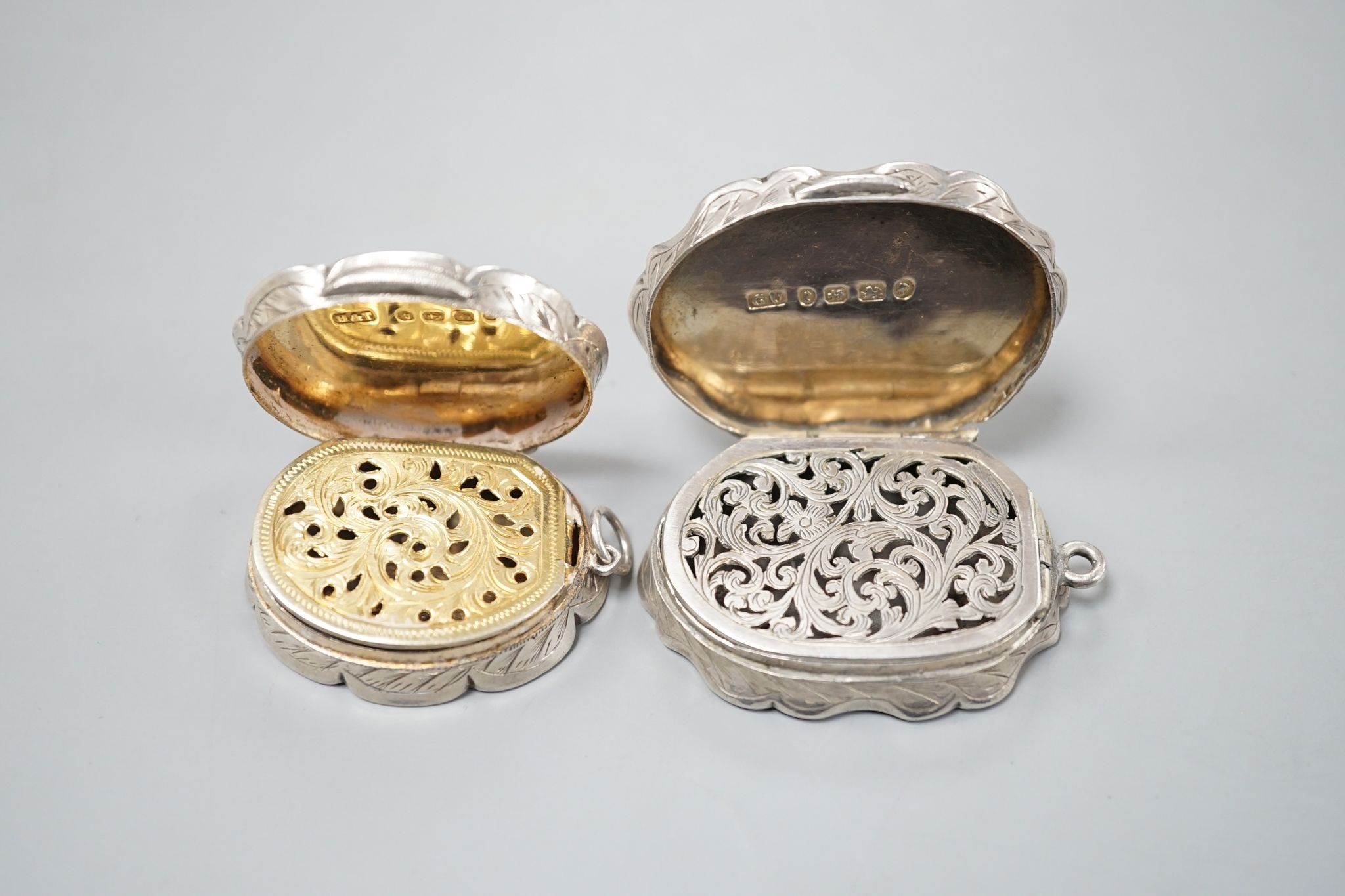 A Victorian engraved silver cusped oval vinaigrette, Hilliard & Thomasson, Birmingham, 1882, 39mm and a larger vinaigrette by George Unite, with engraved inscription.